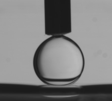 A water drop pressed onto a water-oil interface with surfactants